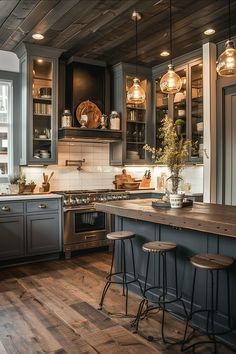 a kitchen with wooden floors and gray cabinets, lights hanging from the ceiling over the stove