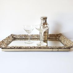 a silver tray with two wine glasses and a decanter sitting on top of it