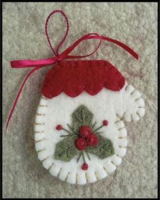 a christmas ornament hanging from a red ribbon