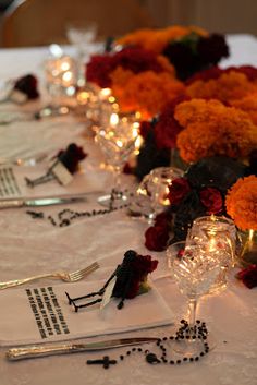 the table is set up with silverware and flowers on it for a formal function