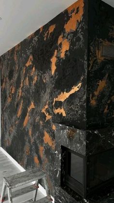 a black and gold wall in the corner of a room next to a fire place