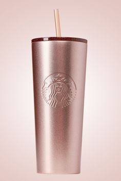 a starbucks cup with a straw in it on a light pink background is seen here