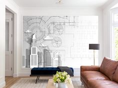 a living room filled with furniture and a large wall mural