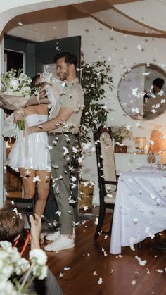 a man and woman standing next to each other in front of a table with confetti on it