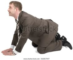 a man in a suit and tie laying on the ground with his hands behind his back