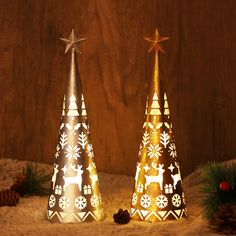 two small christmas trees with lights on them