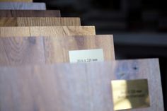 wood samples are stacked on top of each other in rows with price tags attached to them