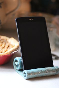 a cell phone sitting on top of a table next to a plate with pies