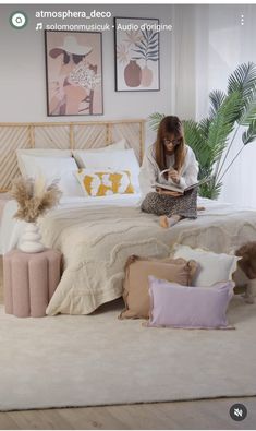 a woman sitting on her bed reading a book