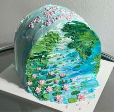 a cake is decorated with water lilies and flowers on the bottom half of it