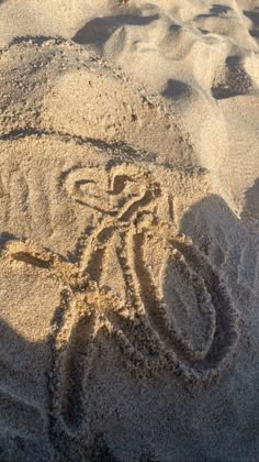 a bicycle drawn in the sand on a beach