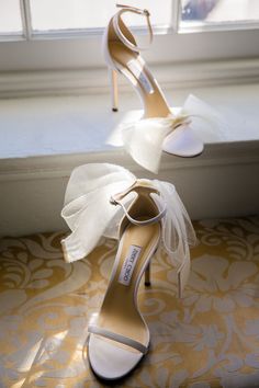 the bride's wedding shoes are on display in front of a window sill