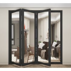 an open room with black folding doors and furniture in the living room is seen through it's glass walls