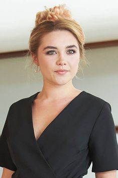 a woman in a black dress posing for the camera