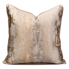 a silver and gold pillow on a white background