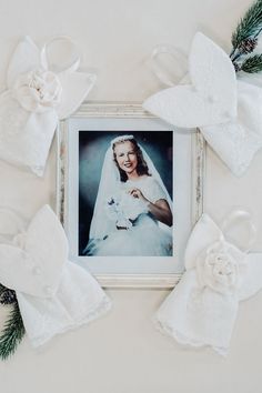 an old photo is surrounded by white angel wings and bows on the wall above it