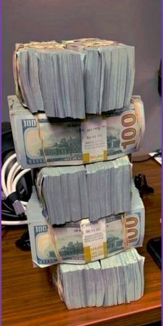 stacks of money sitting on top of a wooden desk