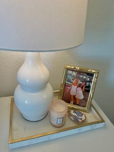 a table with a lamp, photo and other items on it