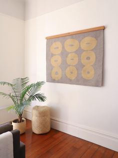 a living room with wood flooring and a painting hanging on the wall above it