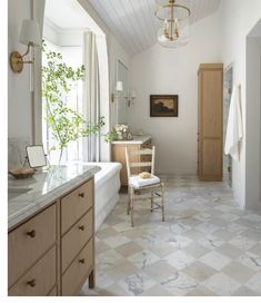 a bathroom with a tub, sink, and mirror in the corner next to a window