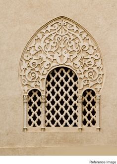 an intricately designed window on the side of a building with lattices and flowers