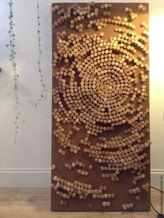 a sculpture made out of wine corks is displayed in the corner of a room