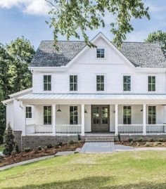 a large white house sitting on top of a lush green field