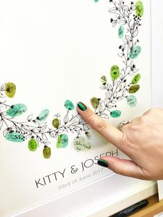 a woman's hand is pointing at the green leaves on a white poster that reads kitty & blossom