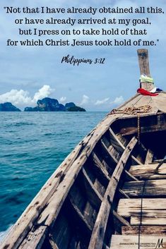 a wooden boat in the ocean with a bible verse on it's front end