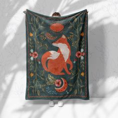 a tapestry hanging on the wall with a red fox and moon design in it's center