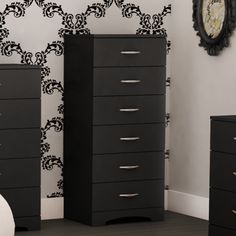 a bedroom with black drawers and a clock on the wall