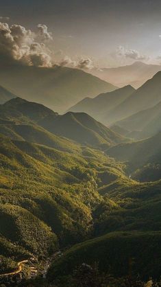 the sun shines through the clouds over mountains and valleys in this scenic photo taken on top of a mountain