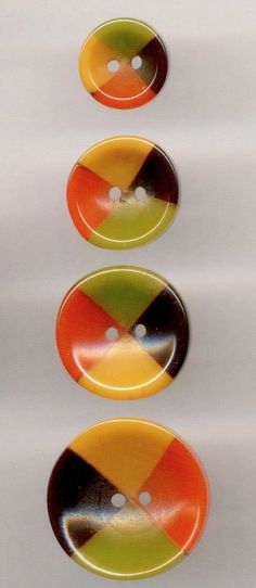 three multicolored buttons are shown on a white surface