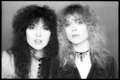 two women with long hair are posing for the camera