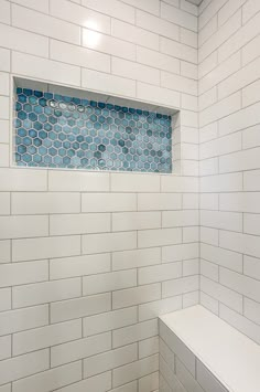 Master bathroom remodel includes glass shower doors with matte-black grids, enclosing an all-tile shower that features a bench seat and Caribbean-blue tiled niche, swarm gray vanity with white marble top, distressed vinyl plank floor, and floating live-edge wood shelving White Shower Blue Floor, Marble Shower With Blue Accent Tile, Tiled Alcove Shower Ideas, Shower Remodel Blue, Blue Shower Niche, White And Blue Shower Tile Ideas, Blue Bathroom Shower Tile, Colorful Shower Tile Ideas, Blue Shower Floor Tile