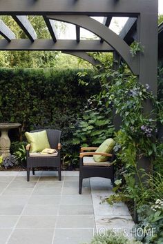 an outdoor patio with two chairs and plants