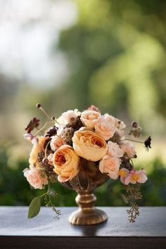 a vase filled with lots of flowers on top of a table