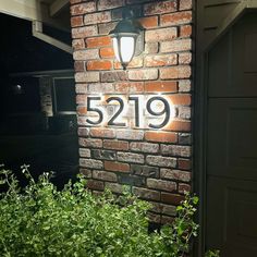 a brick house with the number 5219 on it's side and bushes in front