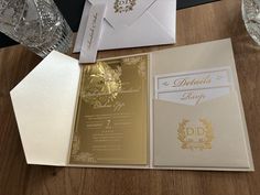 the inside of a wedding card with gold foil on it and an envelope in front