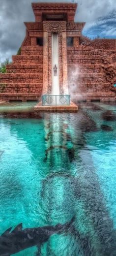 the water is crystal clear and blue in this pool with steps leading up to it