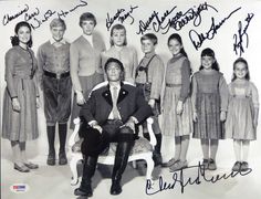 an old black and white photo of a man sitting on a chair in front of a group of children