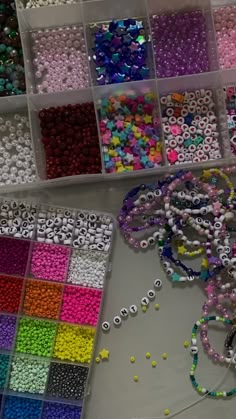 the beads are all different colors and sizes in their bins, along with other bead supplies