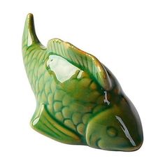 a green fish shaped vase sitting on top of a table