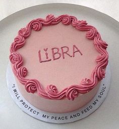 a pink cake with the word libra written on it in cursive writing