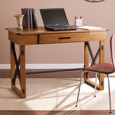 a laptop computer sitting on top of a wooden desk with a red chair next to it