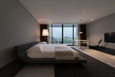 a bedroom with a large bed and a flat screen tv mounted to the side of it