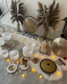 a room filled with lots of different types of candles and plates on the floor next to palm trees