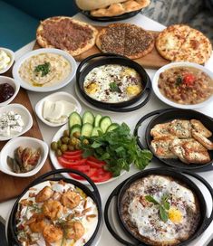 a table topped with lots of different types of food on top of plates and bowls