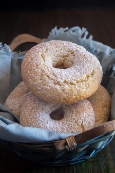 three powdered sugar donuts in a basket