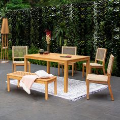 a wooden table with four chairs and a rug on the ground in front of it